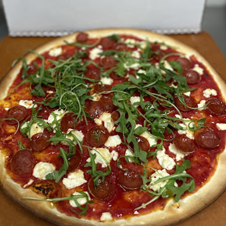 Lion's Den Pizzeria's pepperoni pizza with fresh arugula and dollops of ricotta cheese.