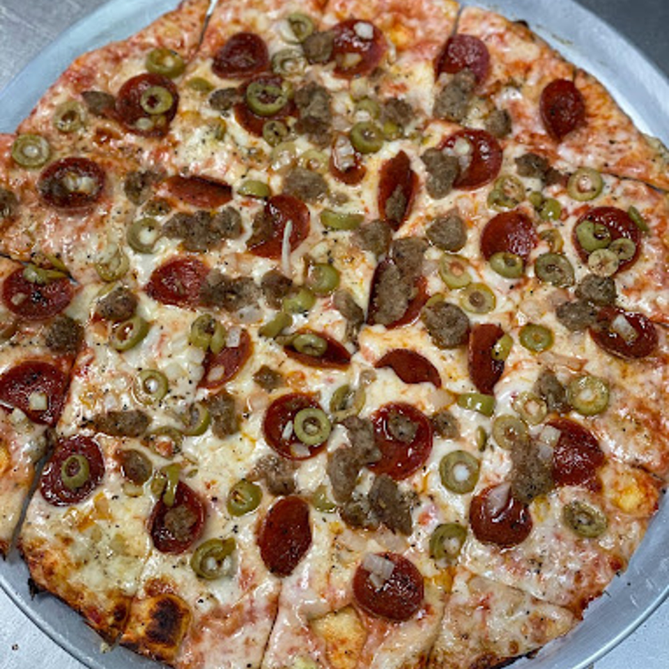A whole Lion's Den Pizzeria pizza with pepperoni, sausage, green olives, and onions.