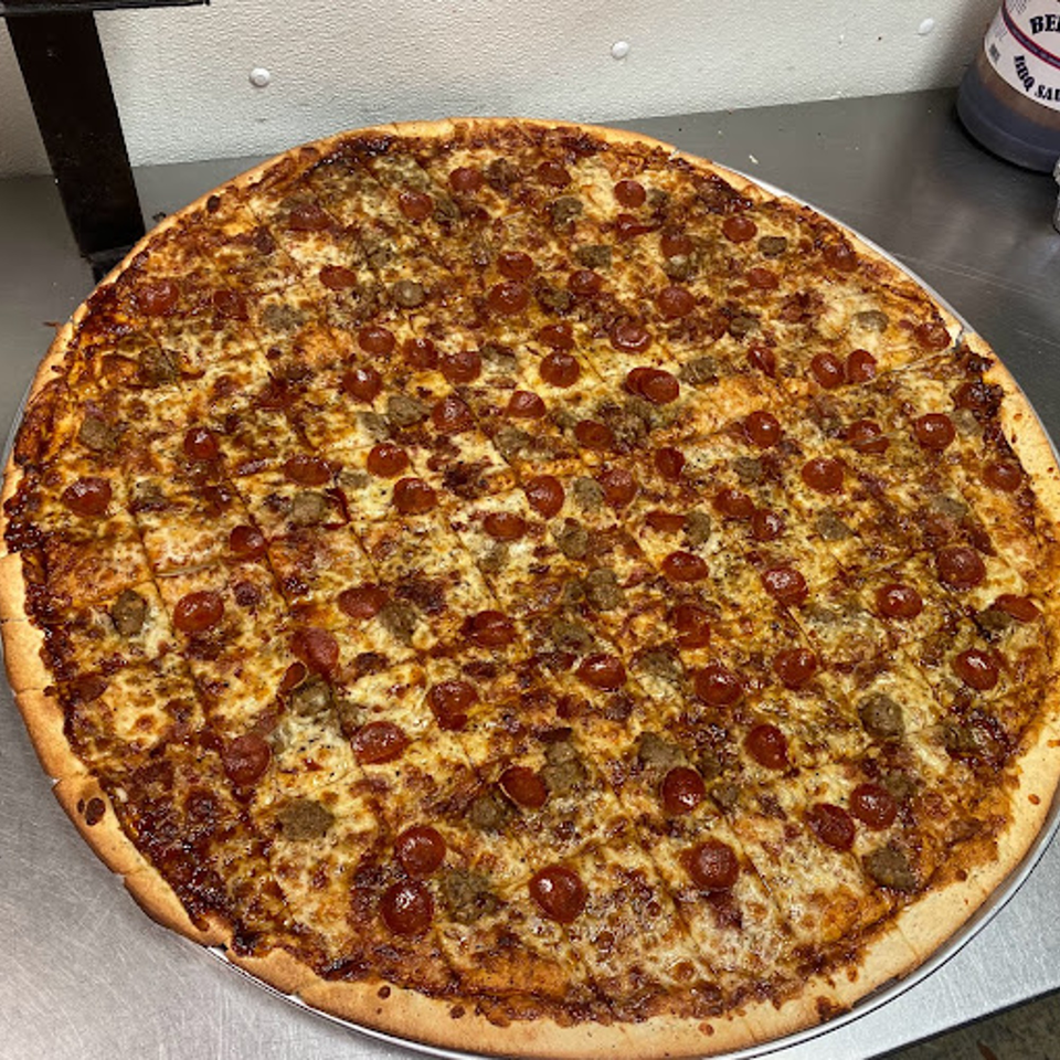 A large, square-cut Lion's Den Pizzeria pizza with pepperoni and sausage toppings.