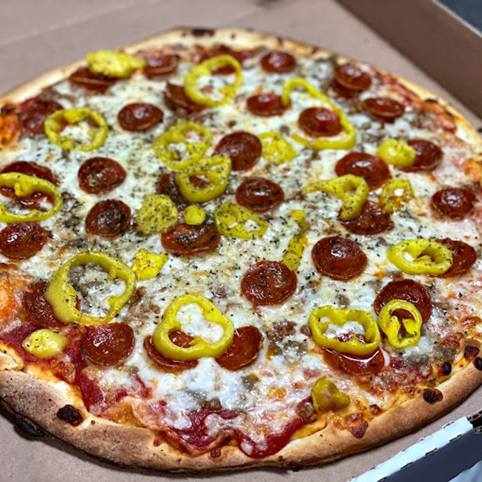 A Lion's Den Pizzeria pizza with pepperoni, sausage, and banana peppers in a box.