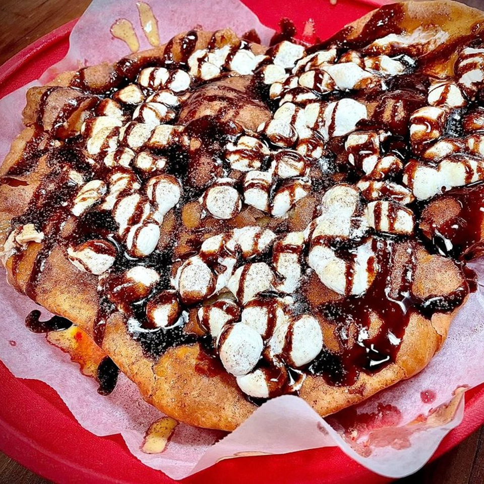 A dessert pizza from Lion's Den Pizzeria, topped with marshmallows and chocolate drizzle.